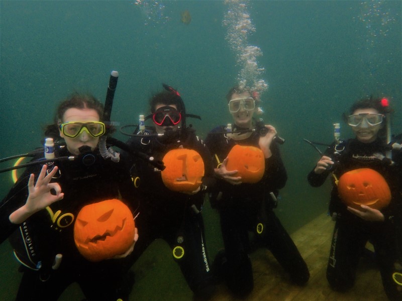 Divers underwater with pumpkins